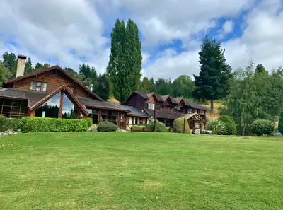 a wooden house set back behind a lawn