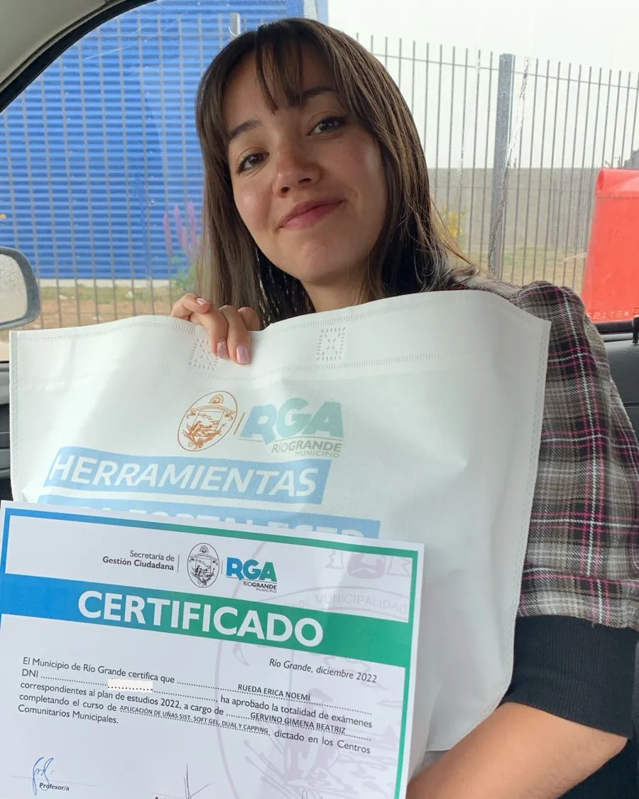 Erica in the car holding up her Rio Grande municipal certificate for the nail-technician course